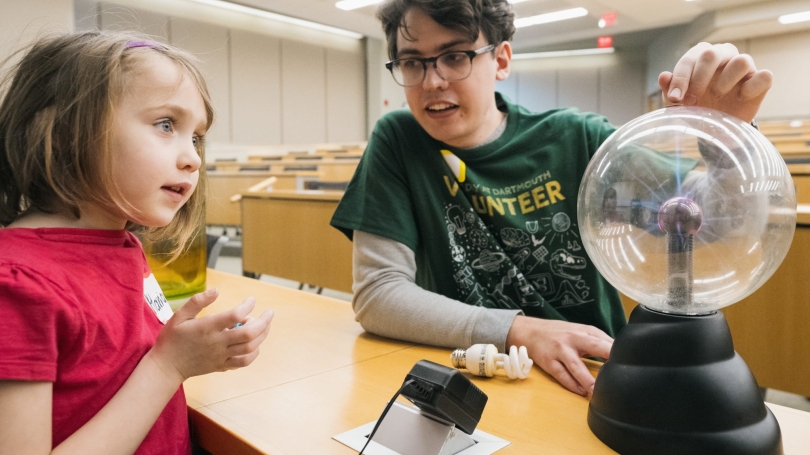 Charlie Acomb, a PhD student in the department of physics and astronomy, demonstrates magnetism and superconductors to a child.